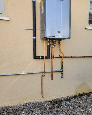 Outdoor tankless water heater. Removed tank water heater that was located inside house.