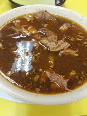 Deep dark brown Birria de Chivo.  Very meaty broth