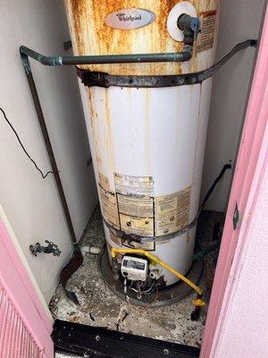 Old leaking water heater before being replaced with a Navien tankless water heater