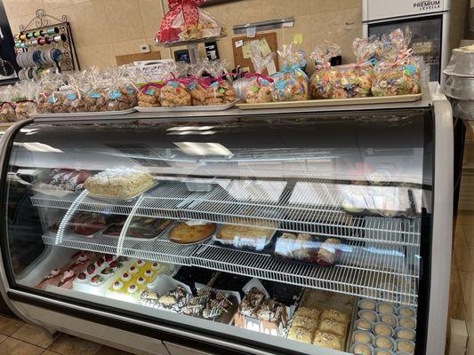 Display case of cakes and desserts, including Gluten Free desserts.