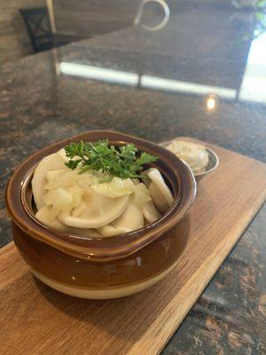 Brown jug with savory dumplings, served alongside creamy sour cream in a mini cup--perfectly hearty and comforting!