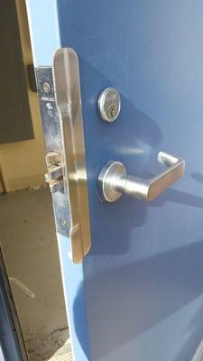 Commercial mortise lock hardware installed with latch protector