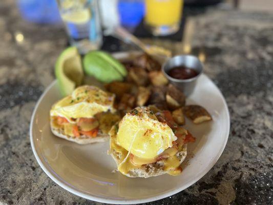 Egg Benedict with potatoes and a side of avocado