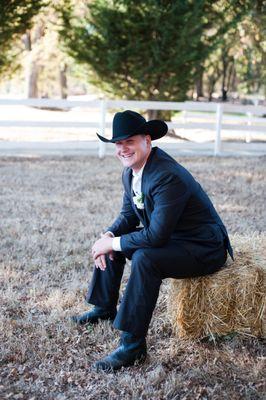 A groom patiently waits. Hay bales are often used in the country style weddings here.