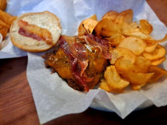 Garlic jalapeño bacon burger with chips for a side.