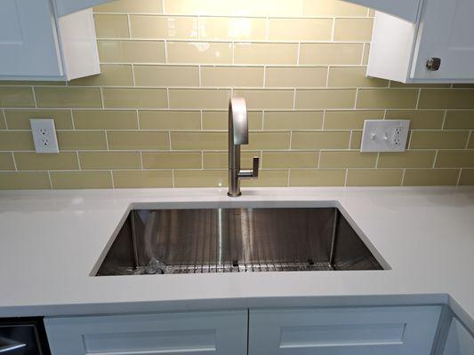 Undermount 16 guage stainless sink and yellow subway backsplash.