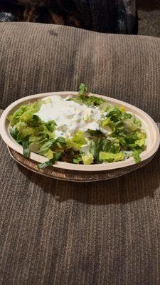 Bowl with chicken,cheese,lettuce,sour cream,pinto beans,white rice.