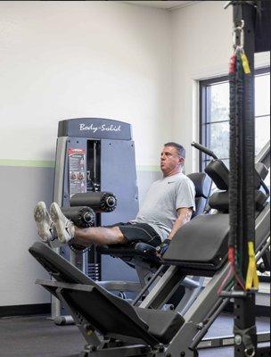 Client hard at work on the leg extension machine!