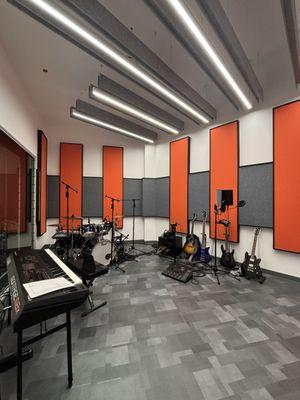 Music room equipped with drum sets, electric guitars, keyboards, and more!