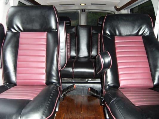 Customized conversion van with installed wood floors, entertainment system and chrome wheels.