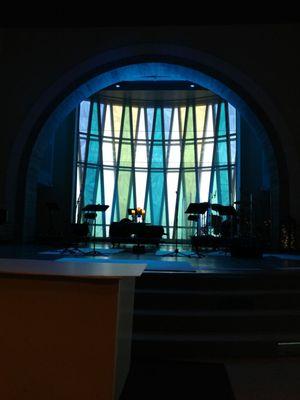 The stained glass window behind the stage.