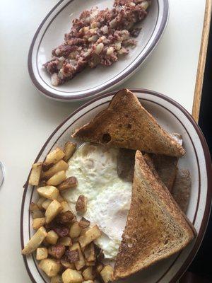 Eggs over easy, toast sausage, home fried and corned beef hash