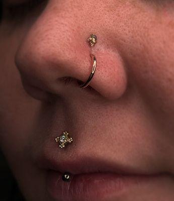 Pierced this jestrum (an upper lip piercing) into a 14 karat gold end. We also adorned her nostrils with some fresh 14 karat gold jewelry.