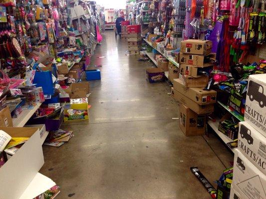 Typical aisle with merchandise on the floor and disheveled shelves.