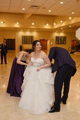 The groom, maid of honor, and brother-in-law bustling my dress.