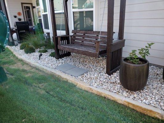 Backyard flowerbed with swing incorporated