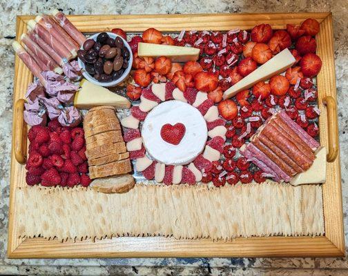 A charcuterie board created for a Valentine's Day party. This board serves 12-15 people.