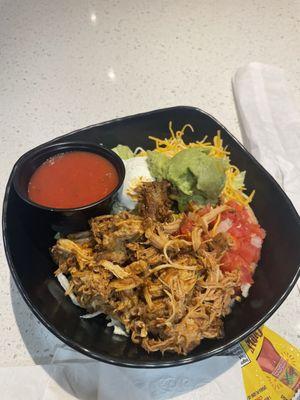 Carnitas burrito bowl with sour cream and guacamole