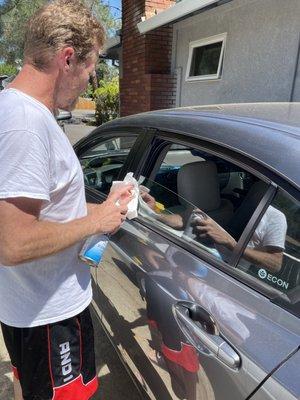 My husband cleaning the top of windows