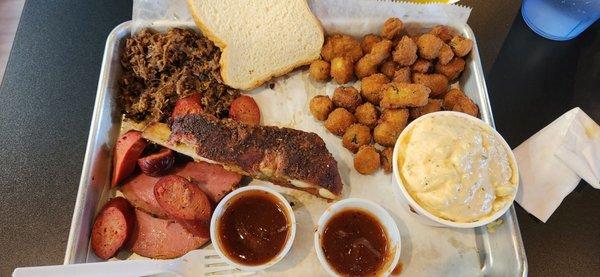 Three Meat Dinner with added Rib (surcharge) with 2 sides, okra and potato salad.  Chopped Brisket, hot link, and bologna,  with the rib.