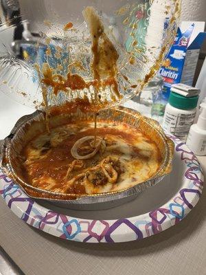 Meat lasagna with a melted plastic lid