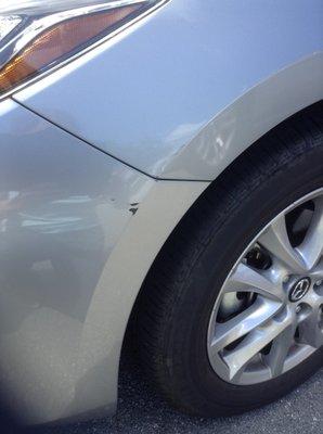 This is my OWN photo of a pre-existing dent w/ paint damage on my Hertz rental car (NONE of the Hertz photos showed this dent).