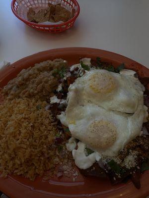 Chilaquiles with sunny side up eggs with rice and beans