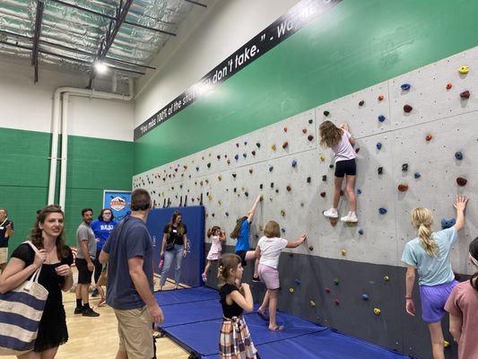 Rock wall adjacent to bounce houses and courts