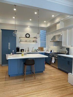 Bold Blue and white two tone kitchen cabinets in shaker style. Open shelves display.