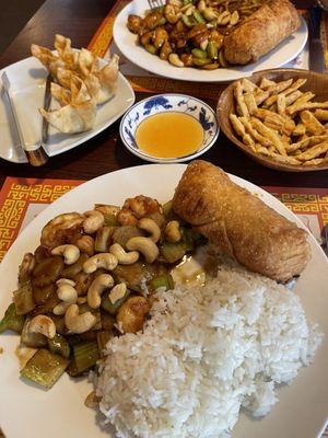 Shrimp with cashews, the other plate is chicken and cashews, there's also crab raccoons and the sesame sticks with duck sauce