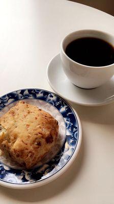 Black coffee and a ham and cheese scone