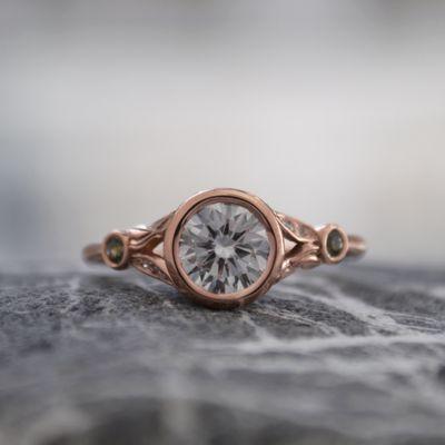 Custom diamond ring in rose gold with green sapphires