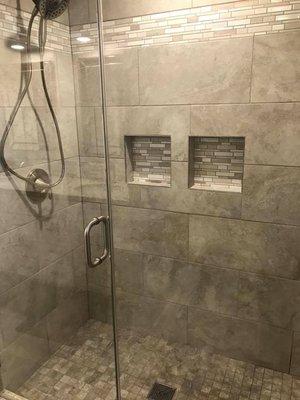 Finished shower remodel with tile and glass doors.