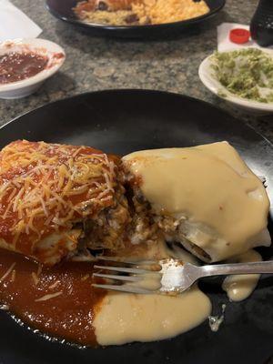 Chicken burrito with half red sauce and half queso.