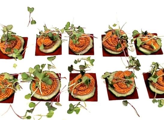 Sun-dried tomato cashew romesco cheese on raw beet bites with Persian cucumbers and micro-greens.