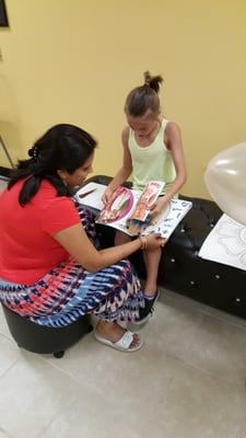 The owner and my daughter picking out henna designs from her catalog.