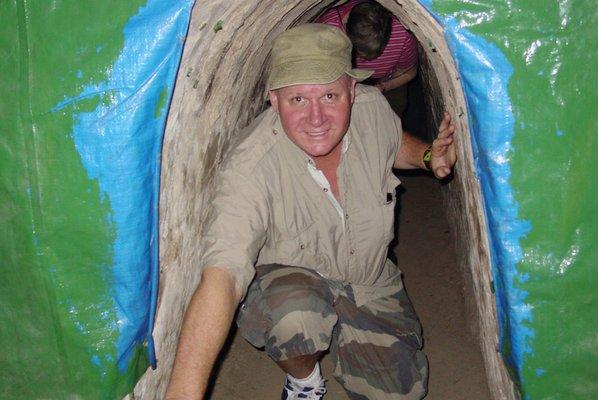 A.C.T. Director Steve Kanold exploring the Cu Chi Tunnels in Vietnam