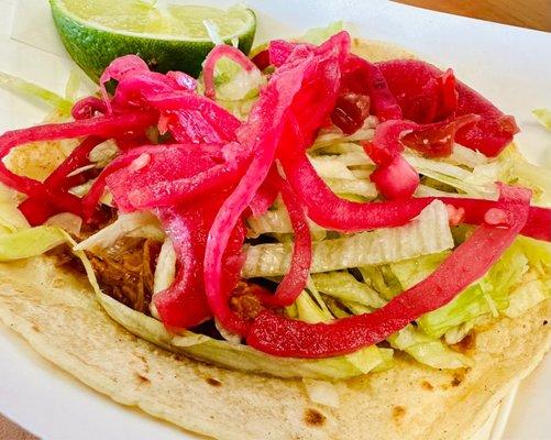 Cochinita Pibil - shredded pork topped with lettuce, red onions and habanero peppers.