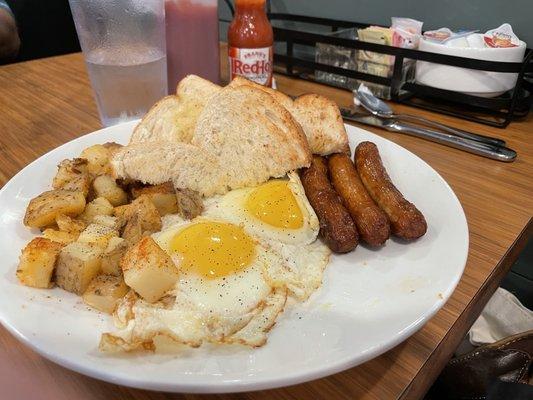 Home fries, sunny side up eggs, sausage links, toast