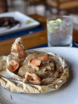 Sea Bass cooked in parchment paper with Shrimp, fingerling potatoes in a delicious lobster sauce.