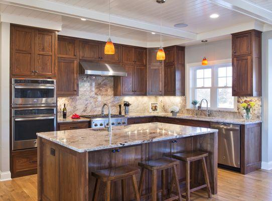 Stunning Walnut kitchen with inset doors, beaded face frame, granite countertop and splash, bead board ceiling, and white oak floors.