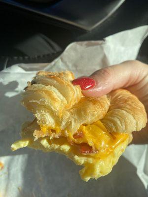 Bacon egg and cheese breakfast sandwich. More than half eaten.