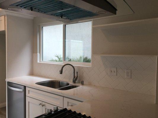 Quartz countertop with herringbone backsplash.