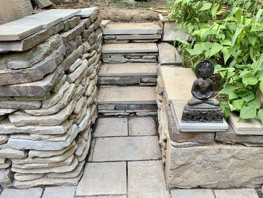 Bluestone retaining wall with steps and patio design.