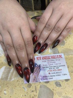 Cat eye nail design with black base and dark blood red top Shape: Long narrow almond (tips dulled to not be sharp like stiletto cat claws)