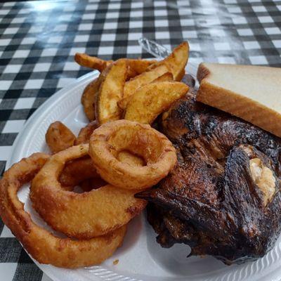 Half chicken, potato wedges, and onion rings