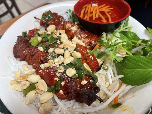 Pork kabob skewers over vermicelli noodles