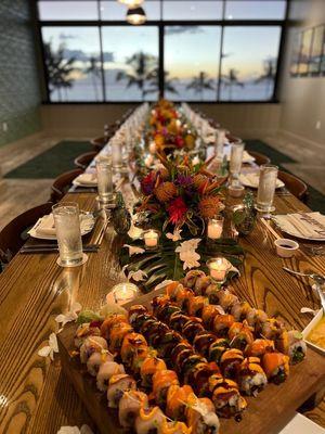 Dinner table with flower arrangements, monstera leaves and orchid heads.