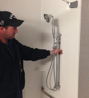 Owner of APD installing a hand-held shower head