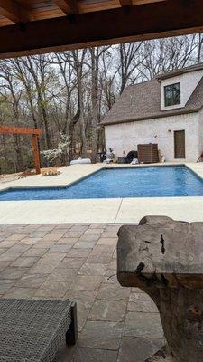 L-shaped pool with tanning ledge and bubblers